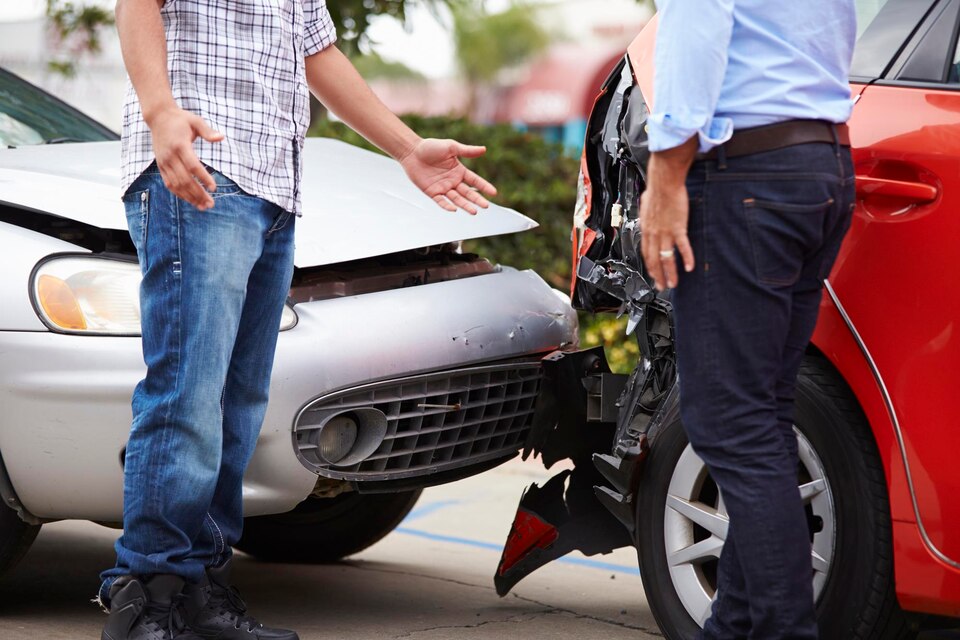 Drivers arguing after a traffic accident, with visible damage to vehicles, emphasizing the aftermath of a collision in Kingwood, Texas.