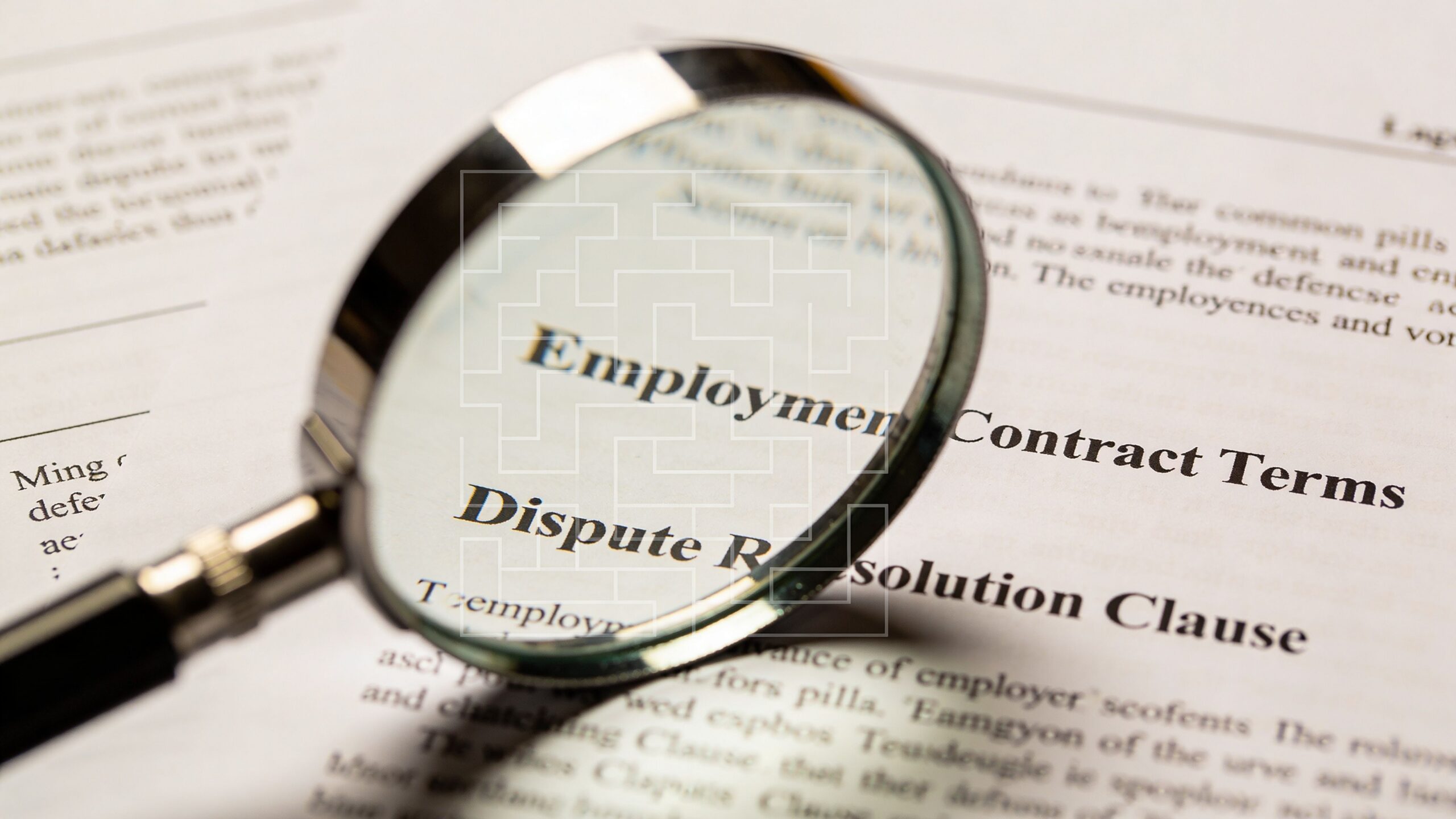 A magnifying glass focusing on the text of an employment contract regarding dispute resolution clauses.