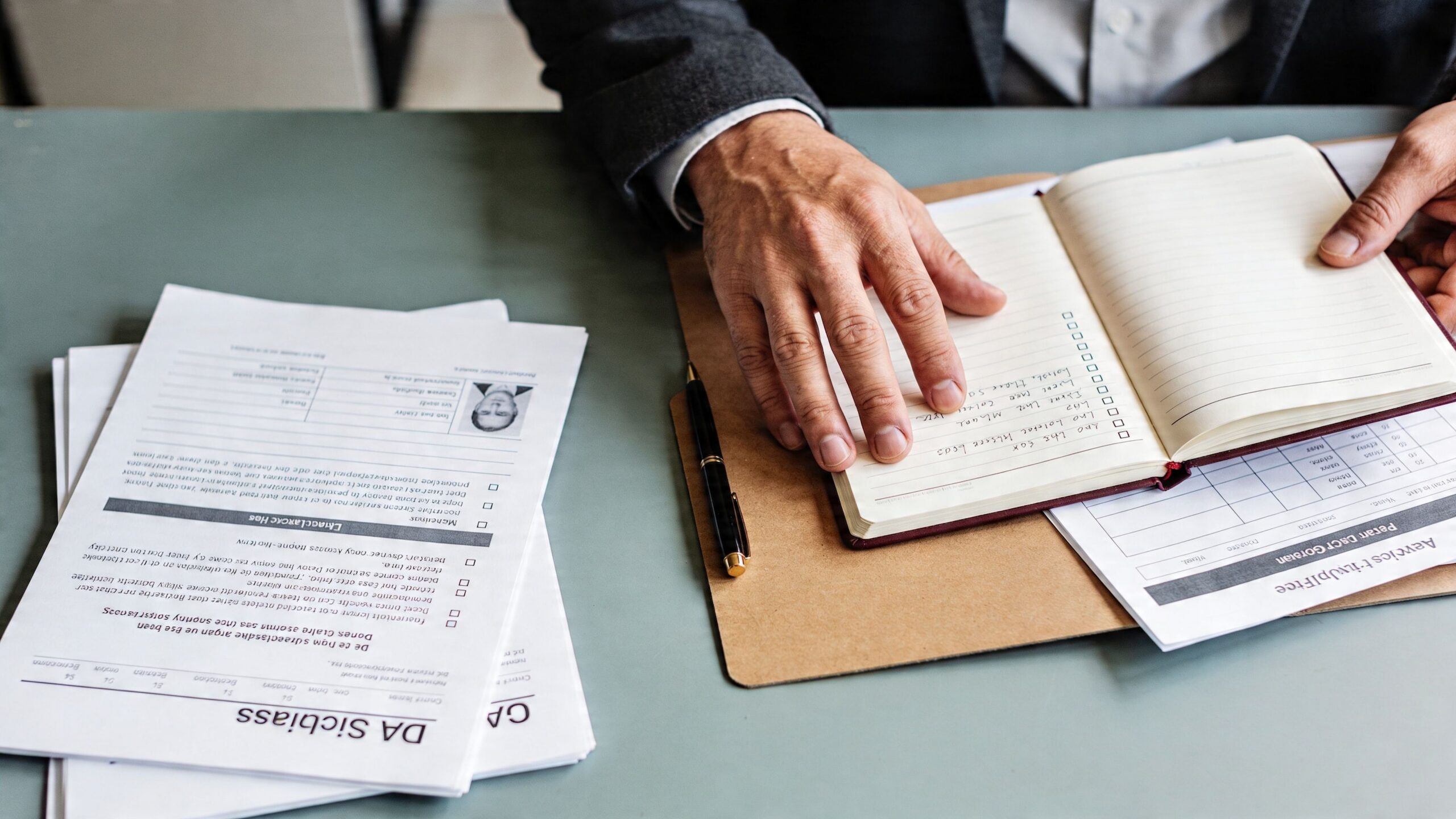 A professional man reviewing documents and notes at a desk while planning his daily business tasks.